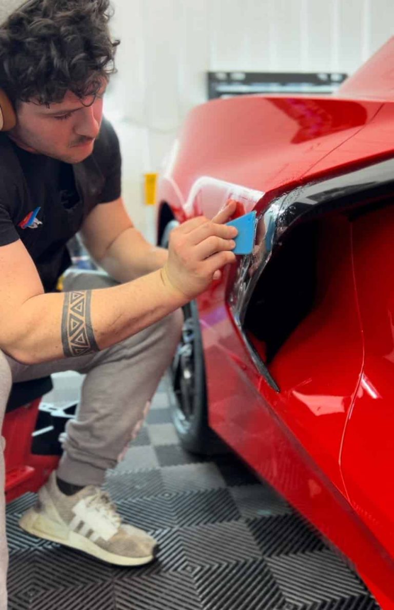 Expert PPF installation process on red sports car