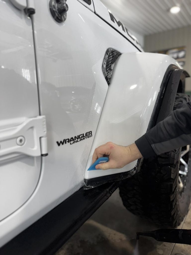 Technician installing PPF on Jeep Wrangler Unlimited fender at Attention To Details